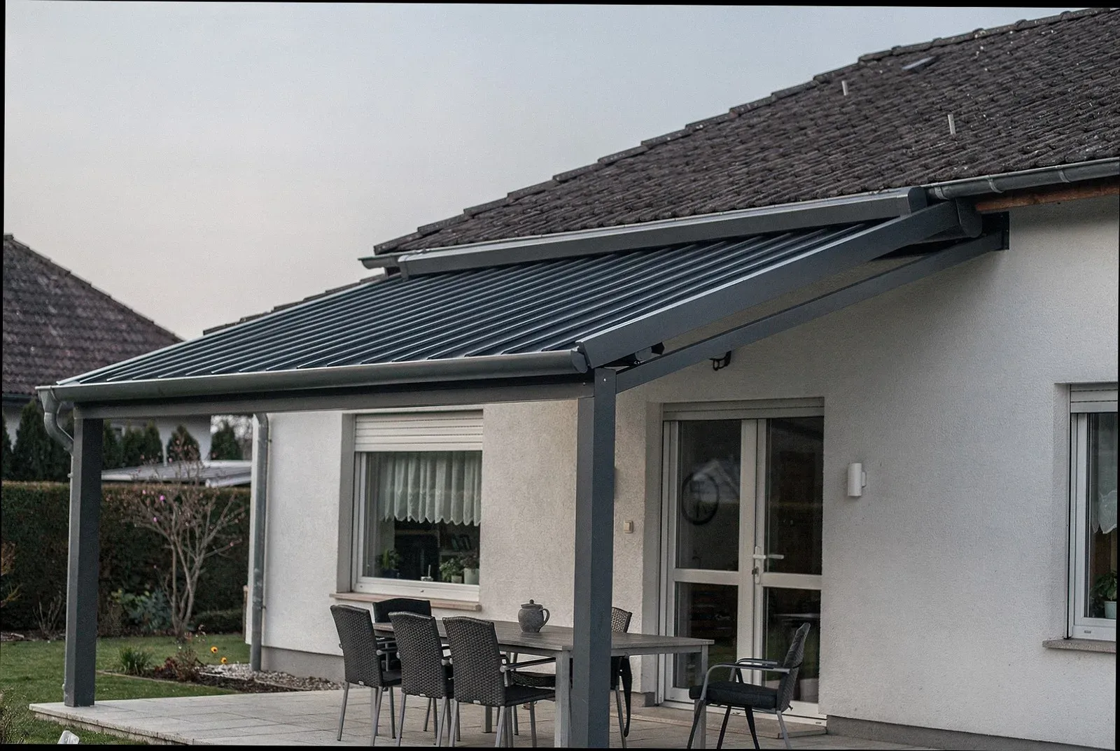 Lamellendach mit schräg gestellten Lamellen über einer Wohnterrasse in Aachen